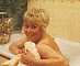 Wendy Richard, in the bath, holding a towel and smiling