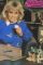 Wendy Richard, dressed in jeans and a blue sweatshirt, sits surrounded by her frog
				 collection